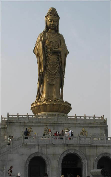 photo of Statue of Golden Guanyin Bodhisattva of the South Seas located at Mount Putuo. Statue stands on top of a white pedestal. The memorial hall inside pedestal displays international and Chinese donations to build statue at Mount Putuo.